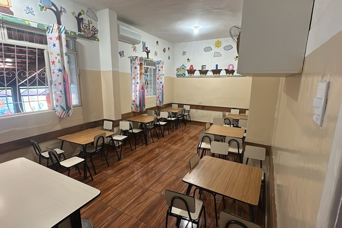 Sala de aula da Escola Infantil Peixinho Dourado, com carteiras individuais e parede decorada